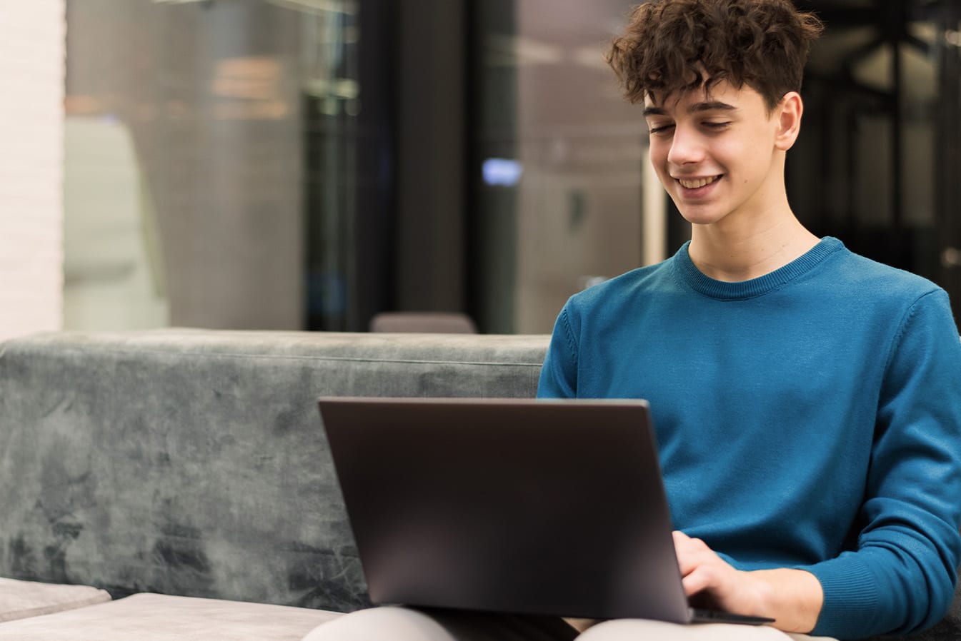Young man smiling while using laptop