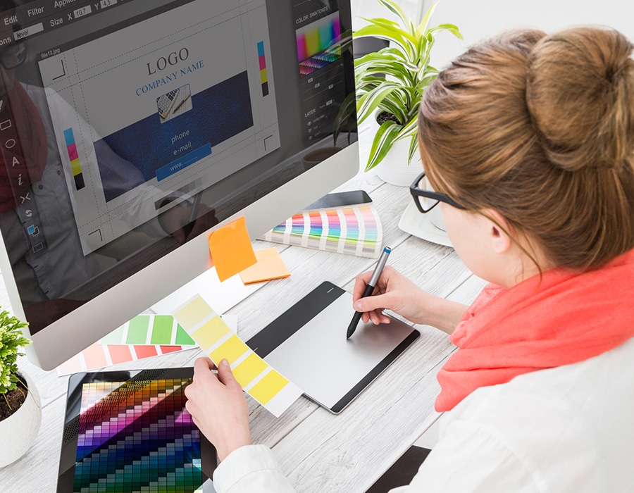 Woman working at computer creating presentation and looking at color palettes