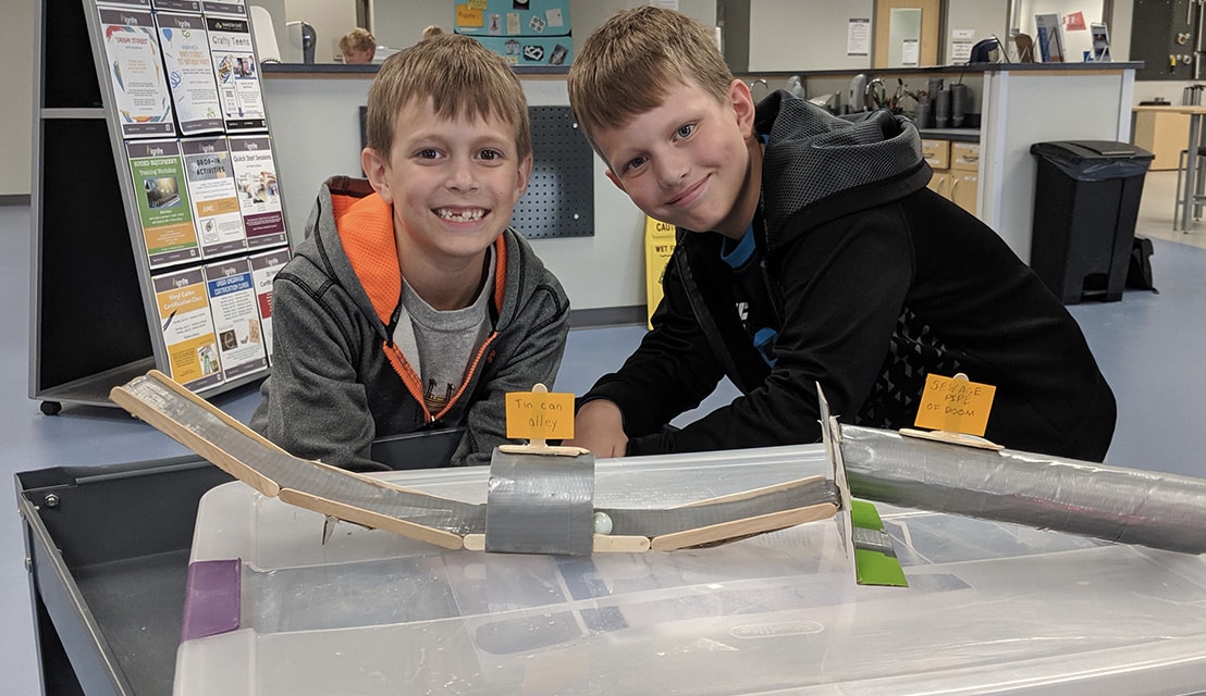 Two boys using a kit in Ignite Studio with Duct tape and paper towel holders