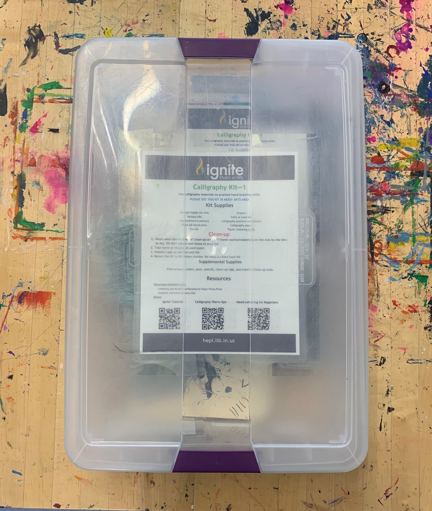 An overhead view of Ignite's Calligraphy Kit, contained in a clear plastic tub.