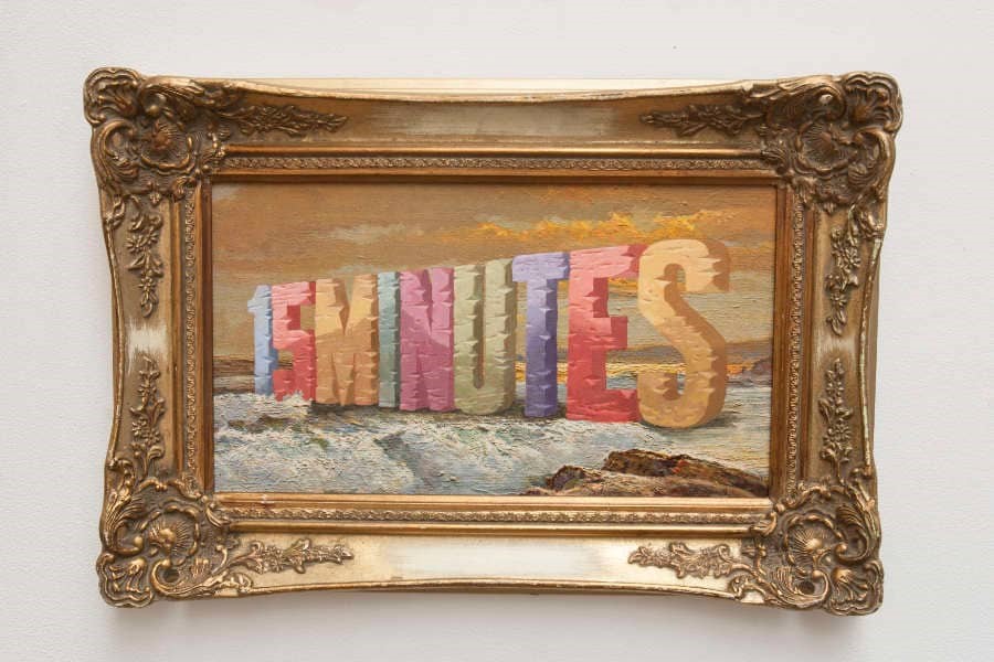 A gold frame surrounds a canvas painted with the phrase "15 Minutes."