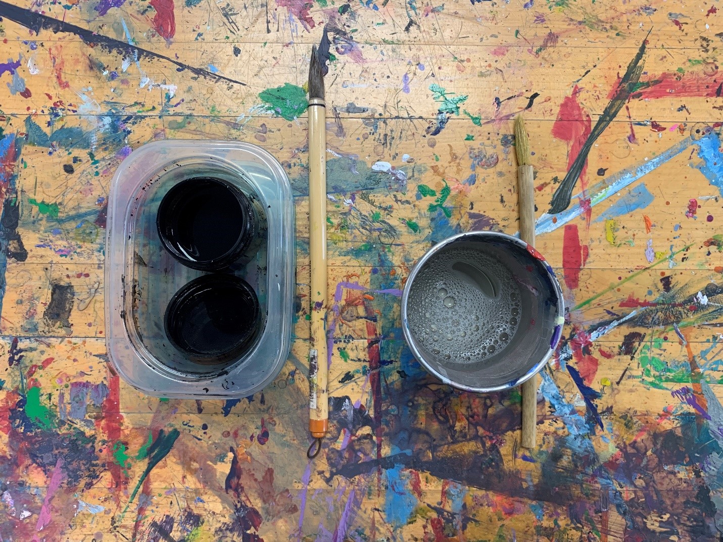 Two small pots of black ink, calligraphy brush, small cup of dispersant