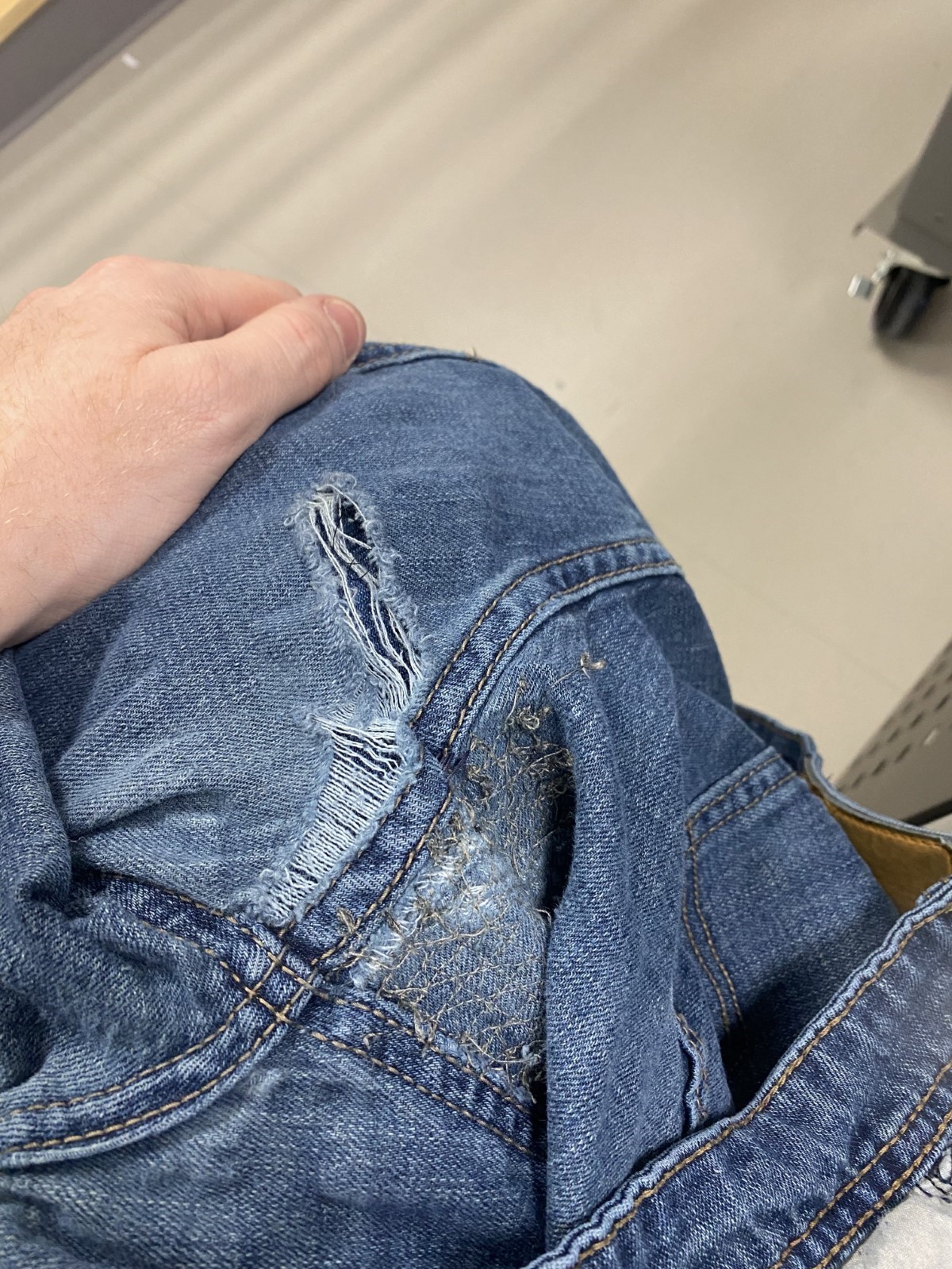 Close up of worn out crotch seams of denim jeans