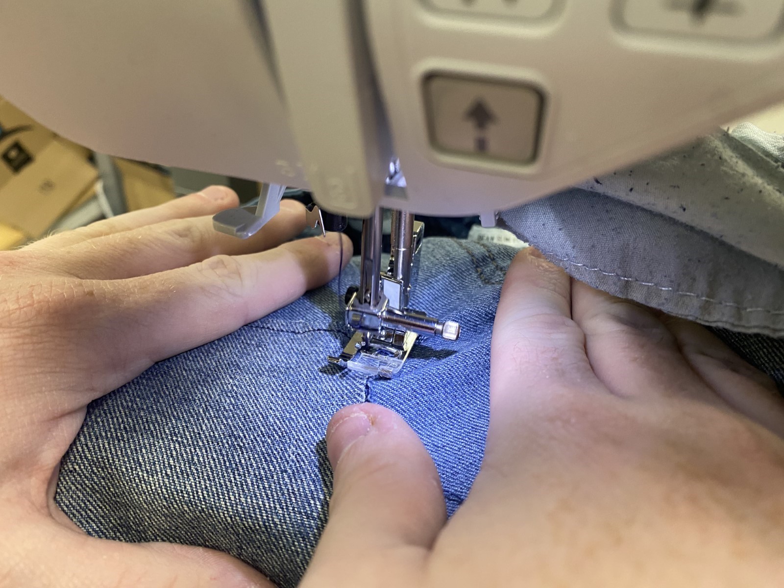 Denim jeans going through the sewing machine