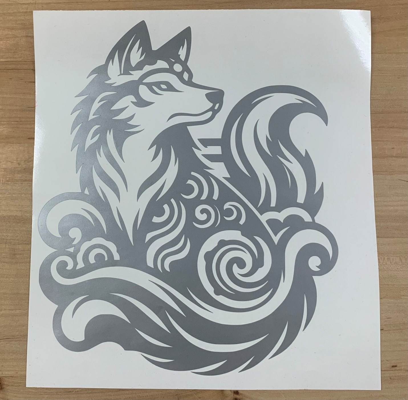 A vinyl cut design of a wolf with swirls.