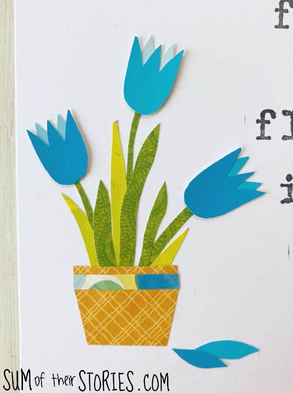 A paper collage of blue tulips in a flower pot.