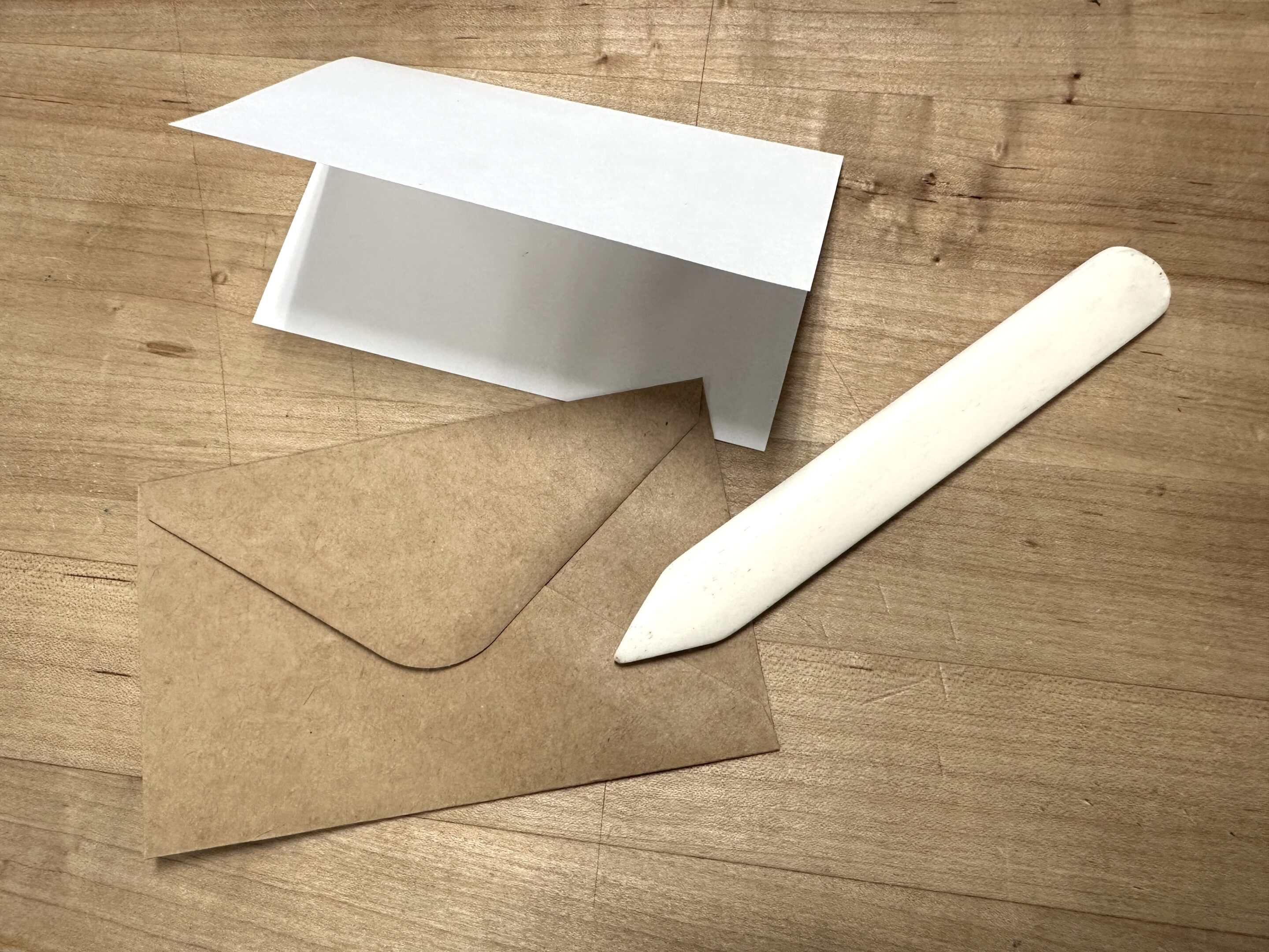 A notecard, brown envelope and paper folder.