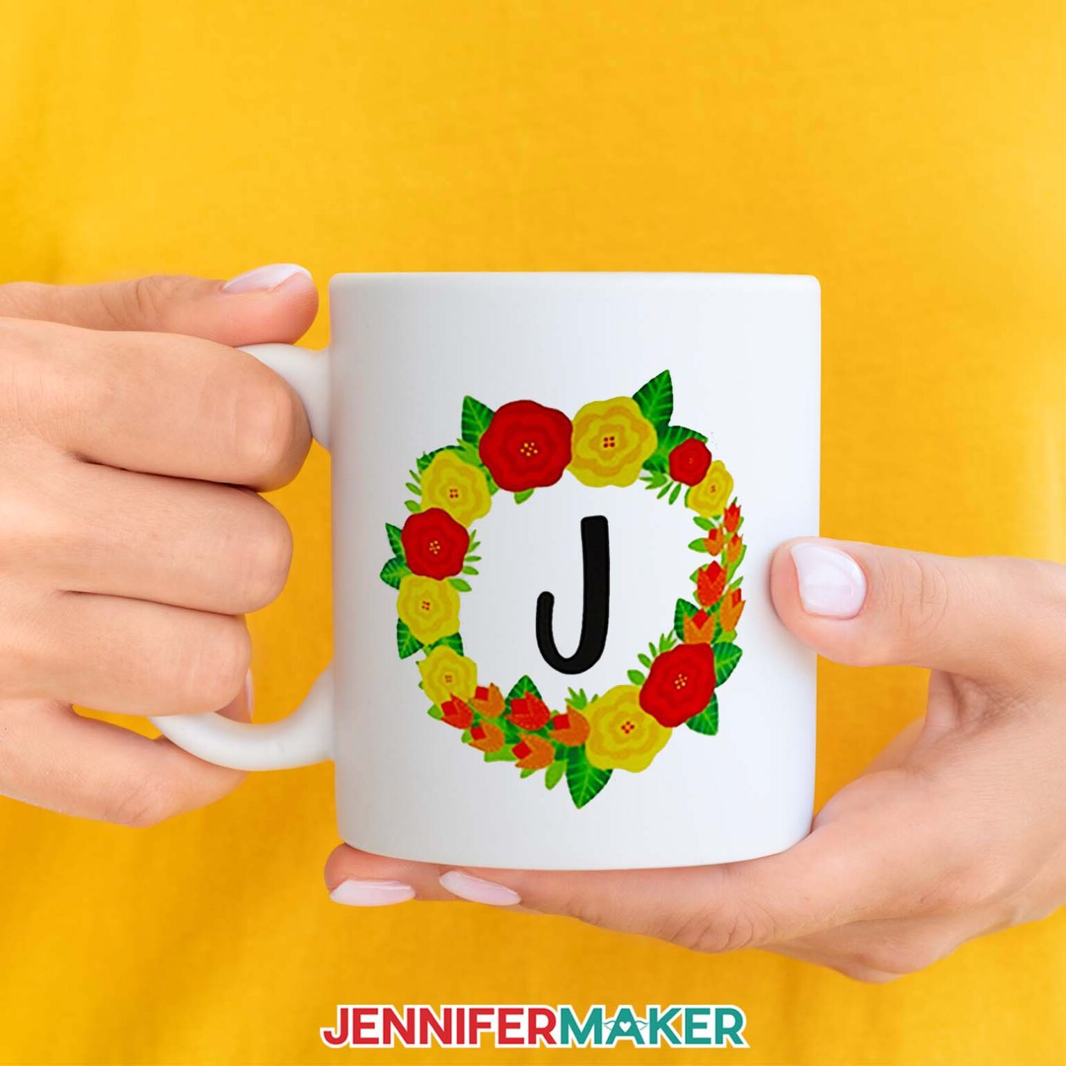 A white mug with the letter J in the middle of a floral wreath that has been sublimated.