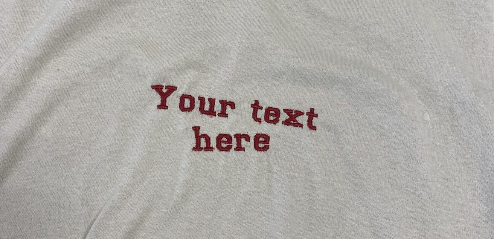 The completed project, embroidered text on a t-shirt that reads "Your text here"