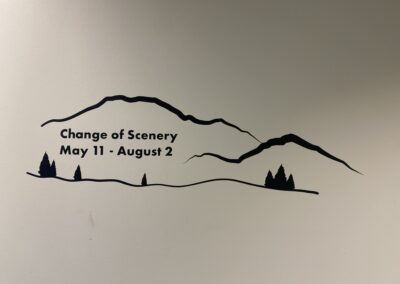 Title wall of exhibit featuring a mountain range the the text "Change of Scenery"