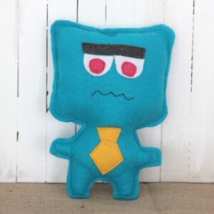 A blue felt monster with pink eyes and a yellow tie.