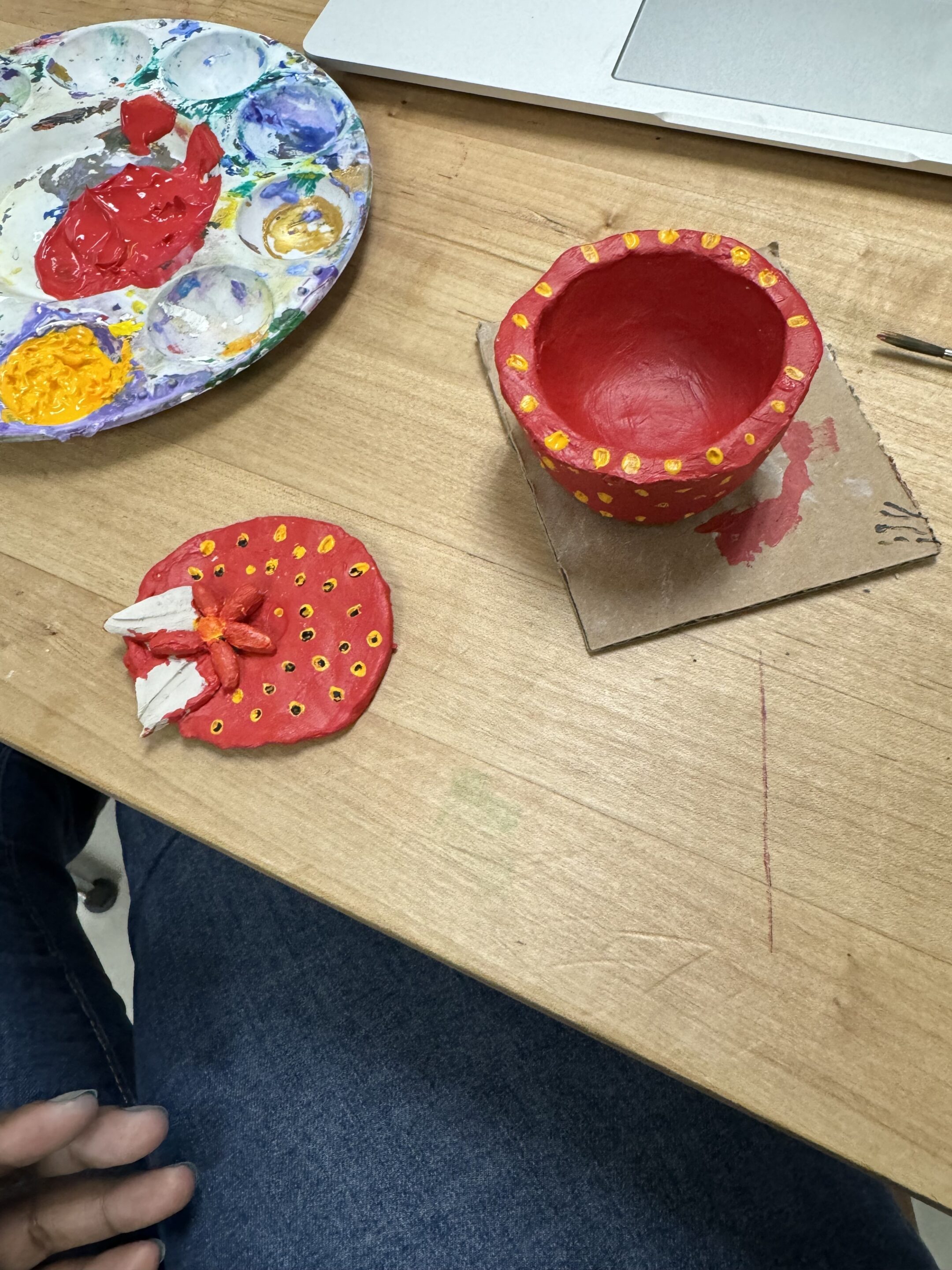 The jar and lid painted red with yellow polka dots.