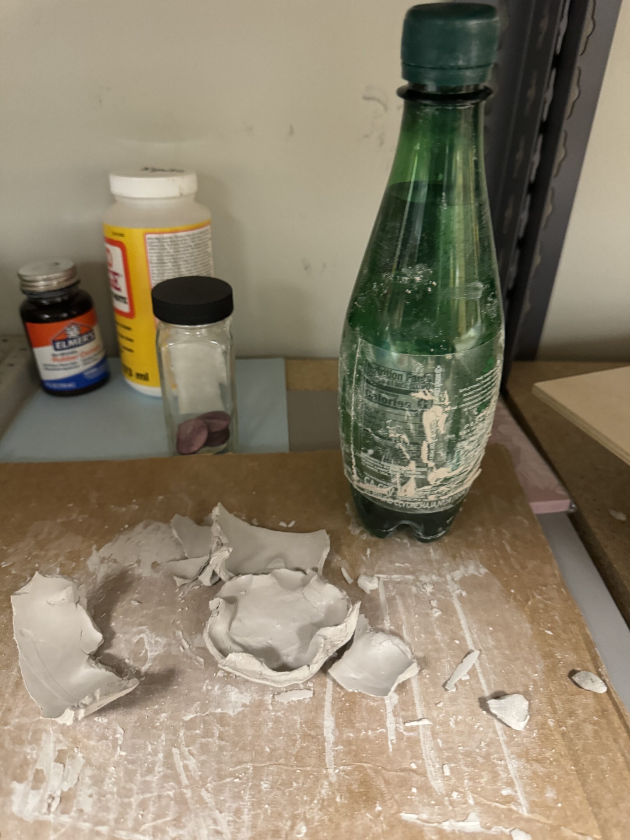 A mush of clay next to a water bottle.