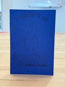 Small blue notebook with text on cover that reads "I made it at Ignite."