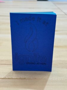 Small blue notebook with text on cover that reads "I made it at Ignite."