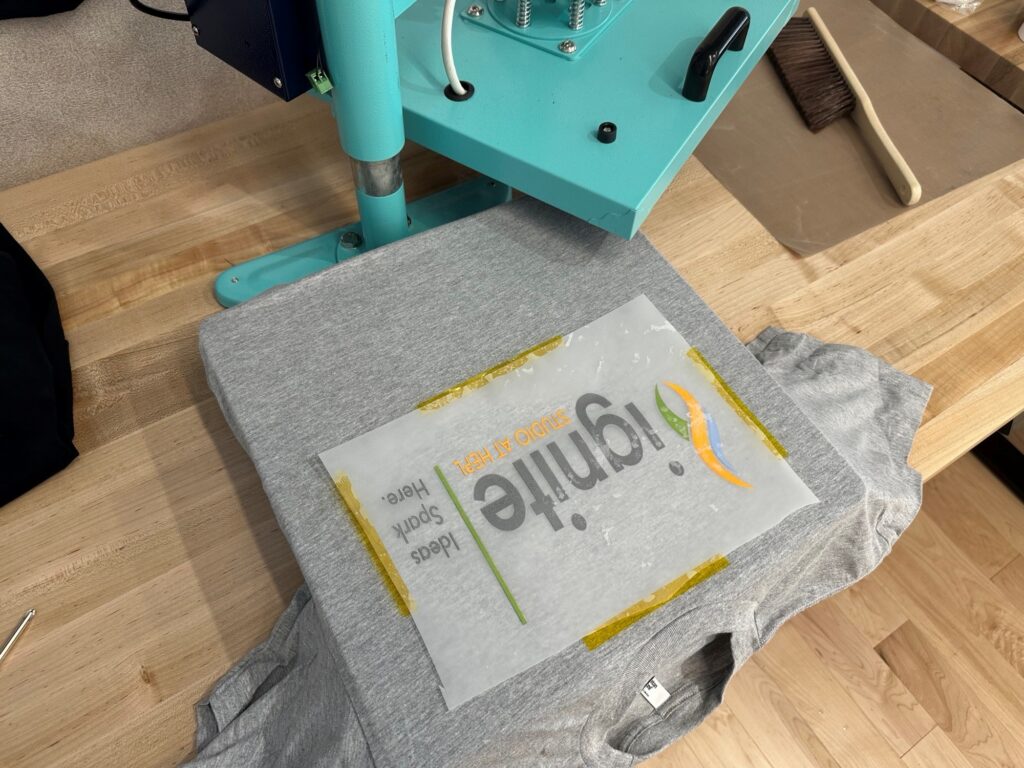 Film transfer sheet placed on t-shirt, ready to transfer image.