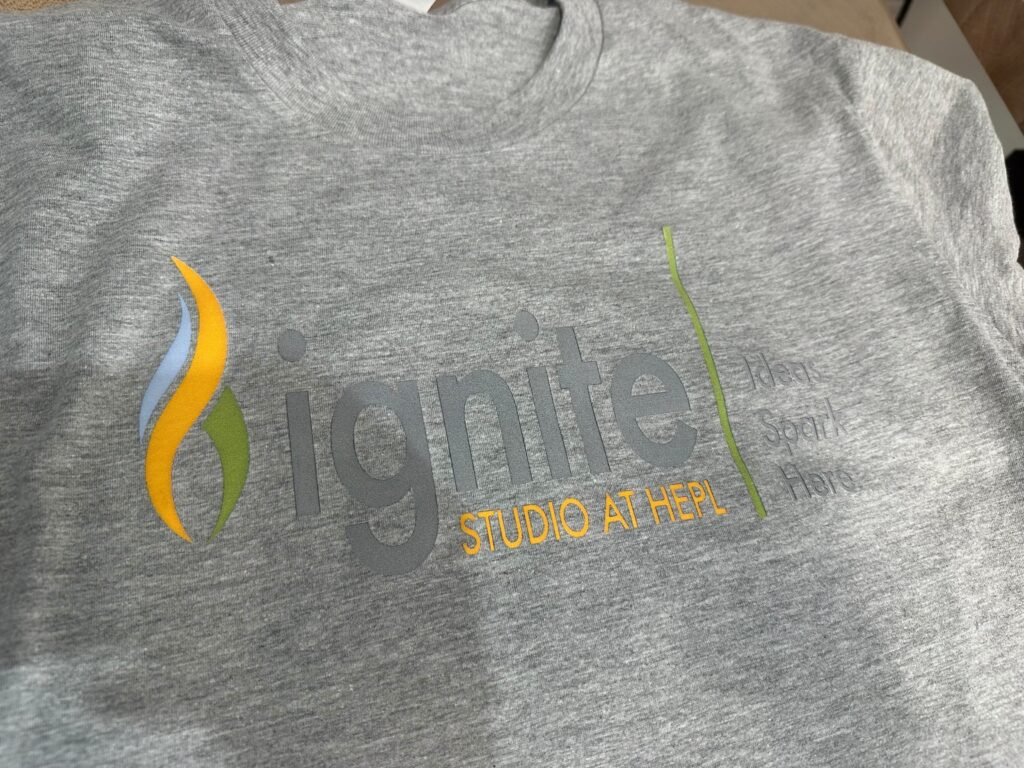 Finished t-shirt with transferred image of Ignite logo.