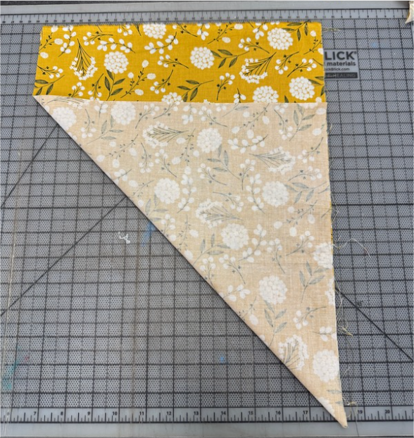 Rectangle of fabric folded corner to edge to create a triangle shape. 