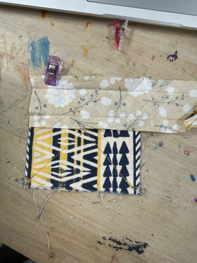 Bias tape attached to coaster square with clips. 