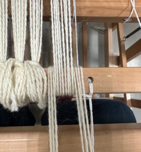 Grouping threads to tie onto bar attached to take up wheel.