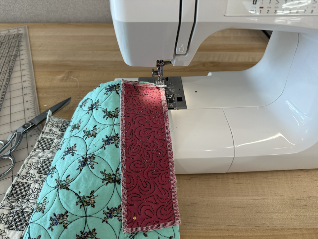 Close up of quilted scraps being sewn together.
